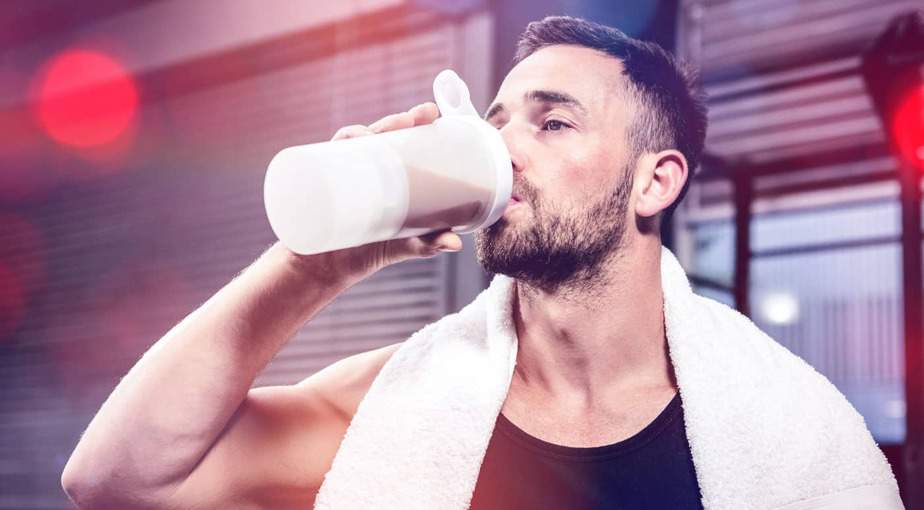 A man drinks a post-workout supplement to encourage muscle growth.