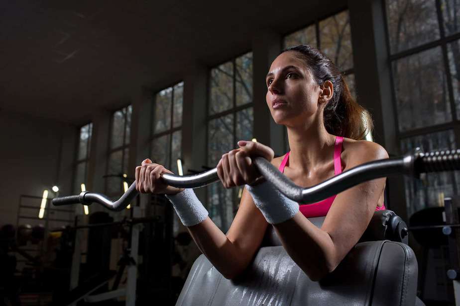 "Can You Lose Weight and Build Muscle at the Same Time?" A woman lifts weights at the gym.