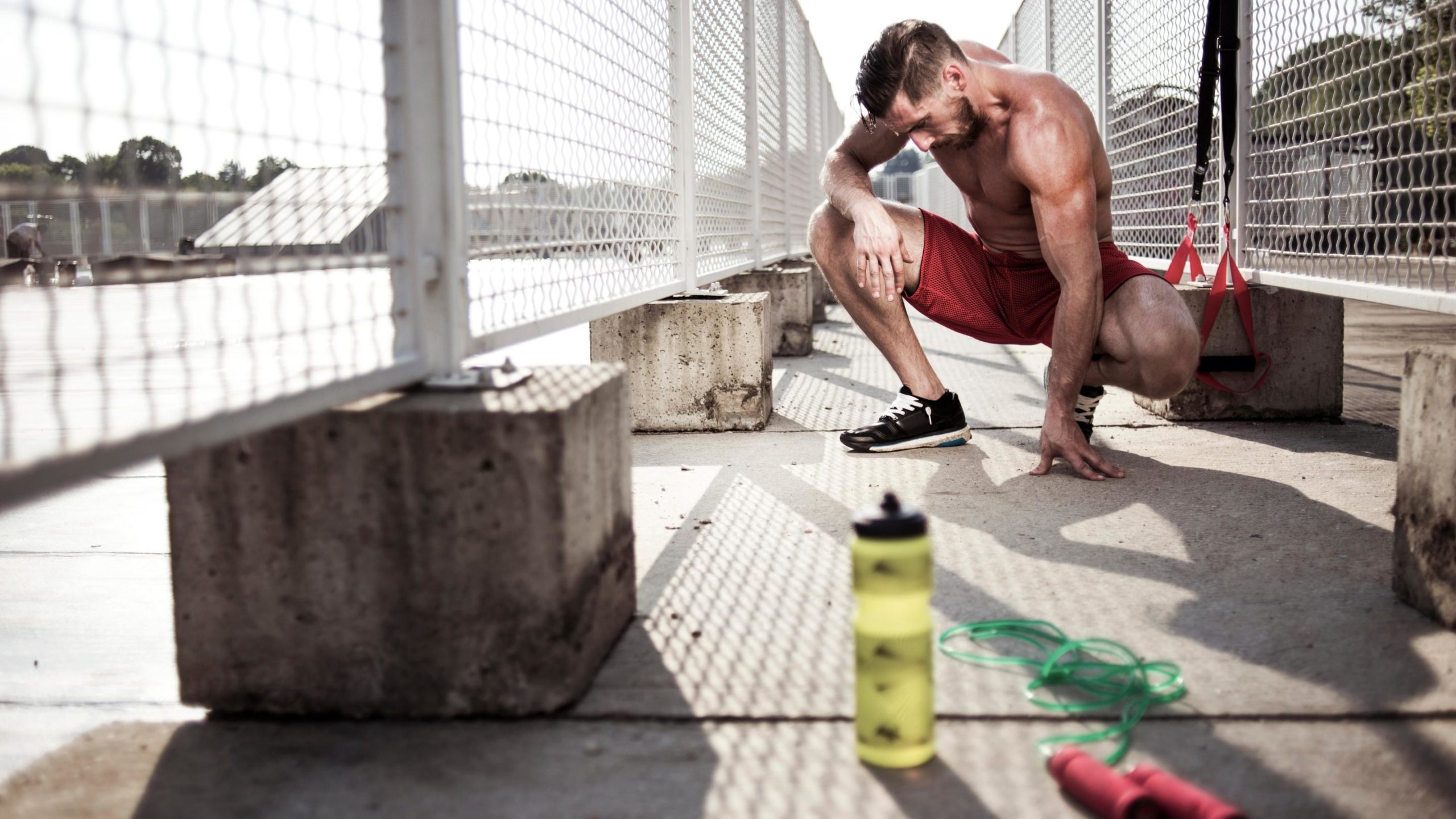 man working out with his electrolyte drink nearby
