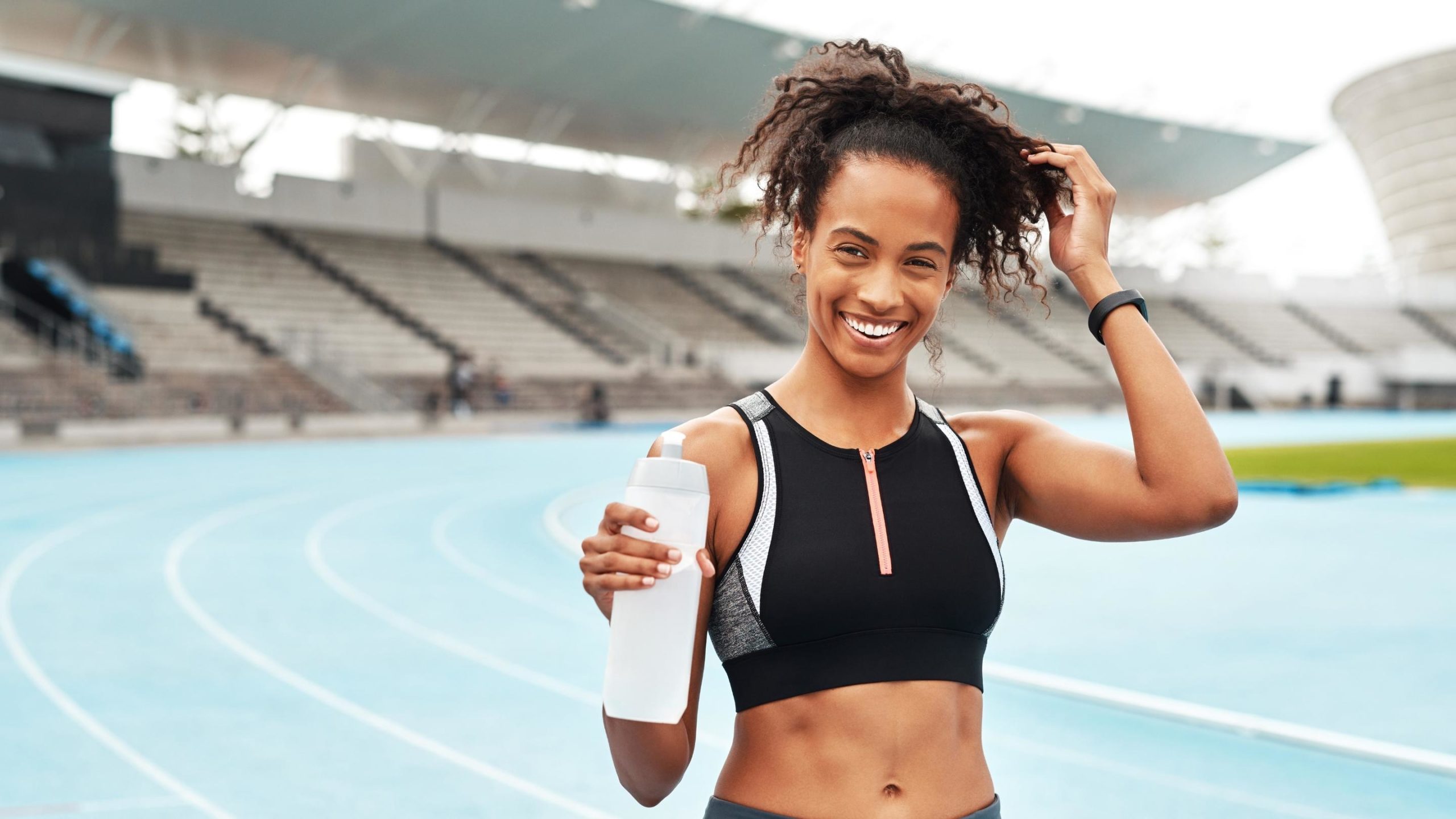 track and field woman athlete holding her electrolyte drink