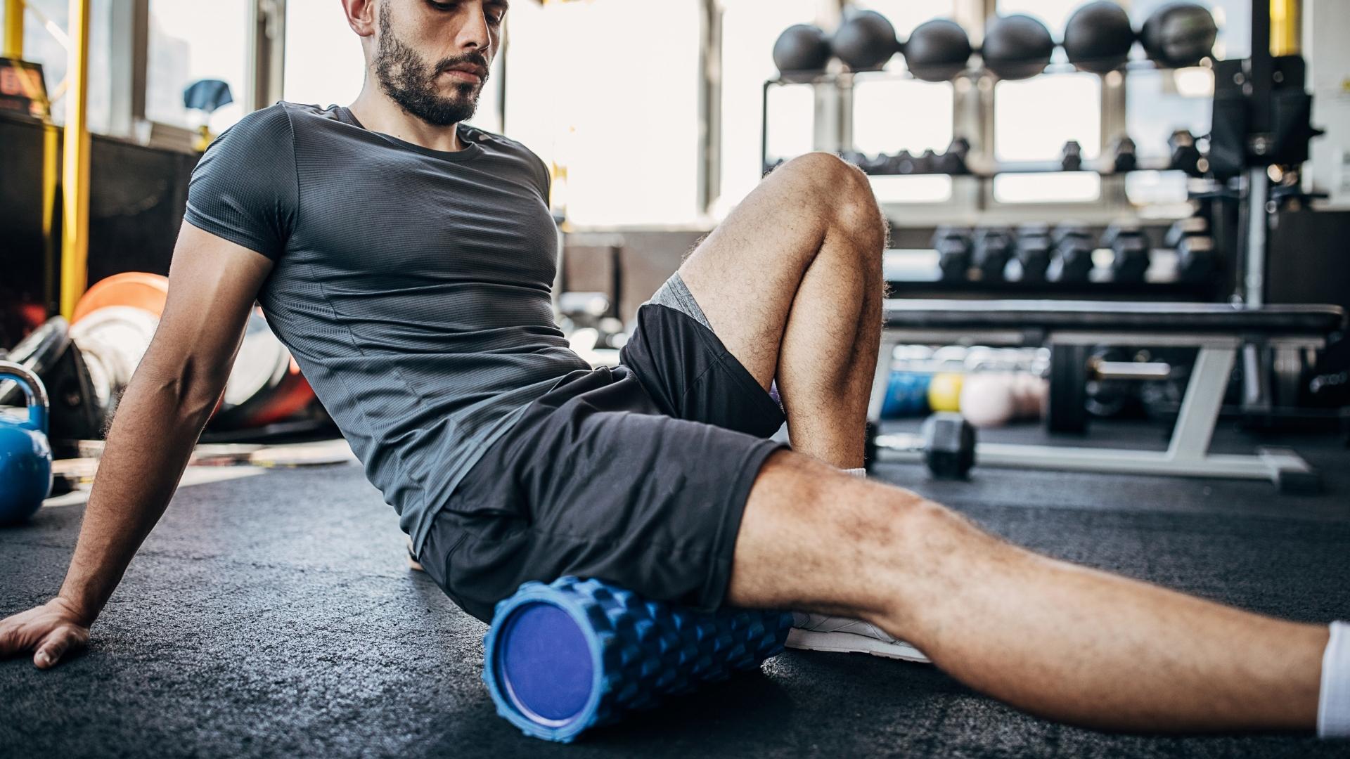 man using foam roller while working out