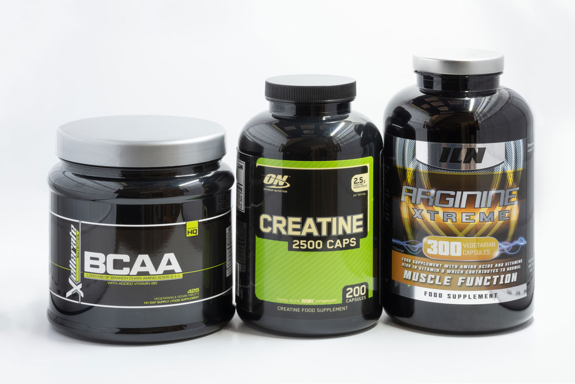 Bottles of BCAA, Creatine and Arginine placed on a table