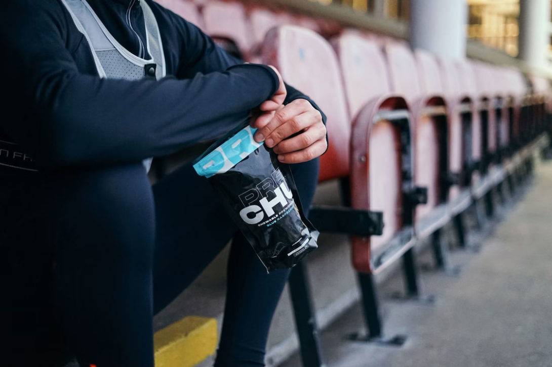 Man holding a pack of pre-workout supplements