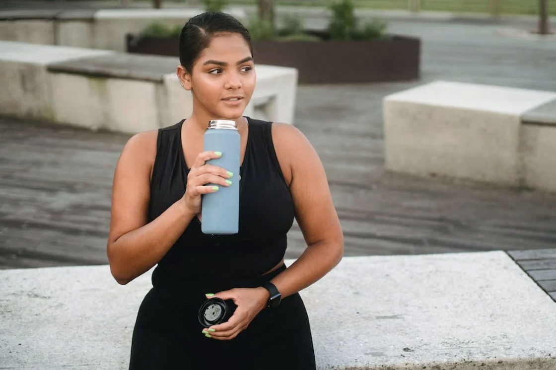 Woman drinking from her blue water tumbler