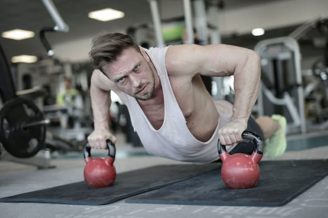 Man doing push up using a pair of kettlebells