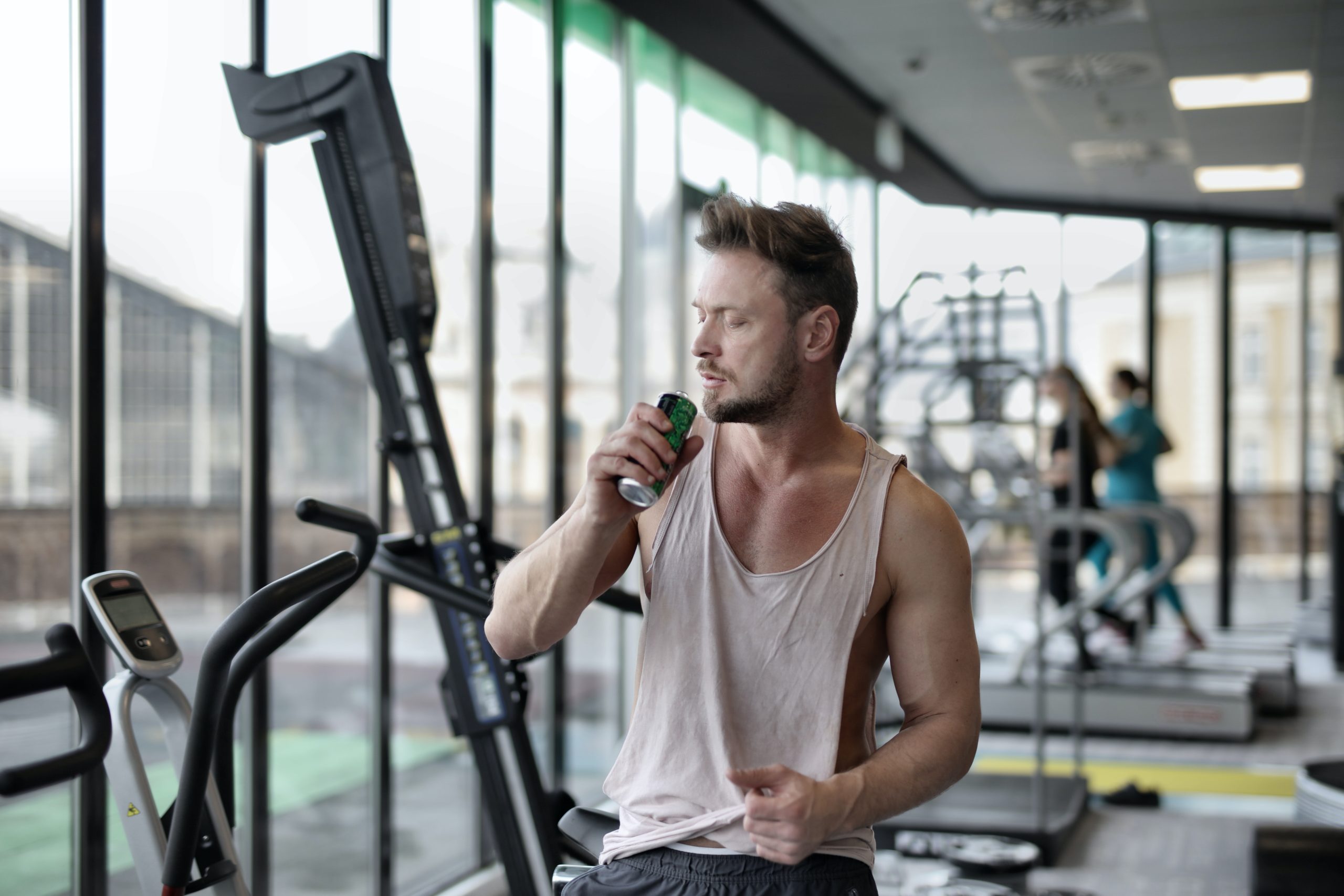 A man drinking a beverage after working out