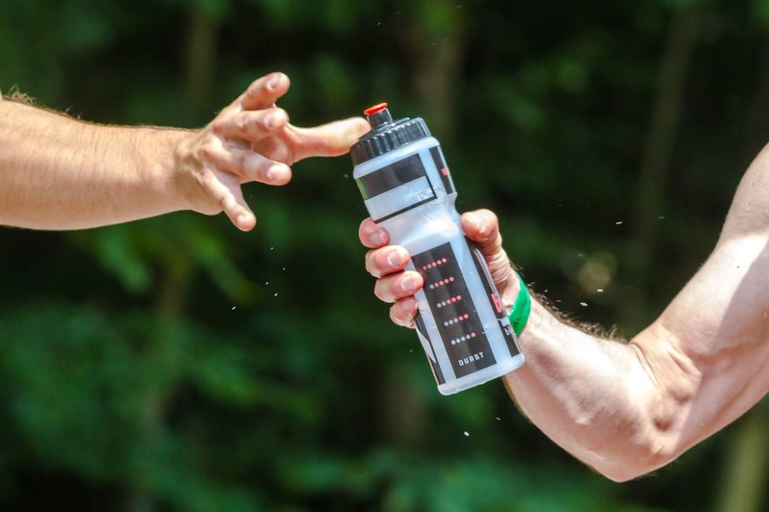 Man passing a water tumbler to his friend