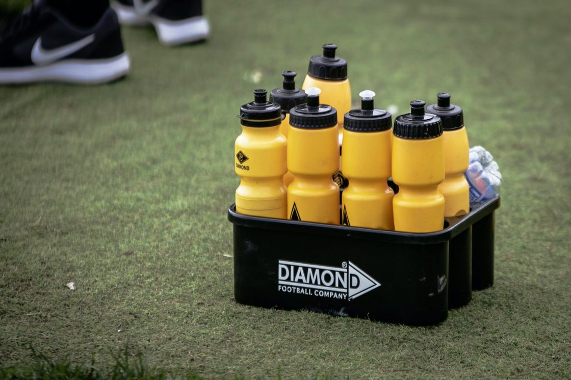 Box of sports drinks on a grass field