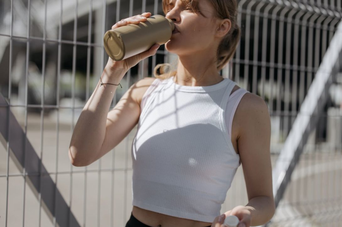 Woman drinking from a brown water tumbler