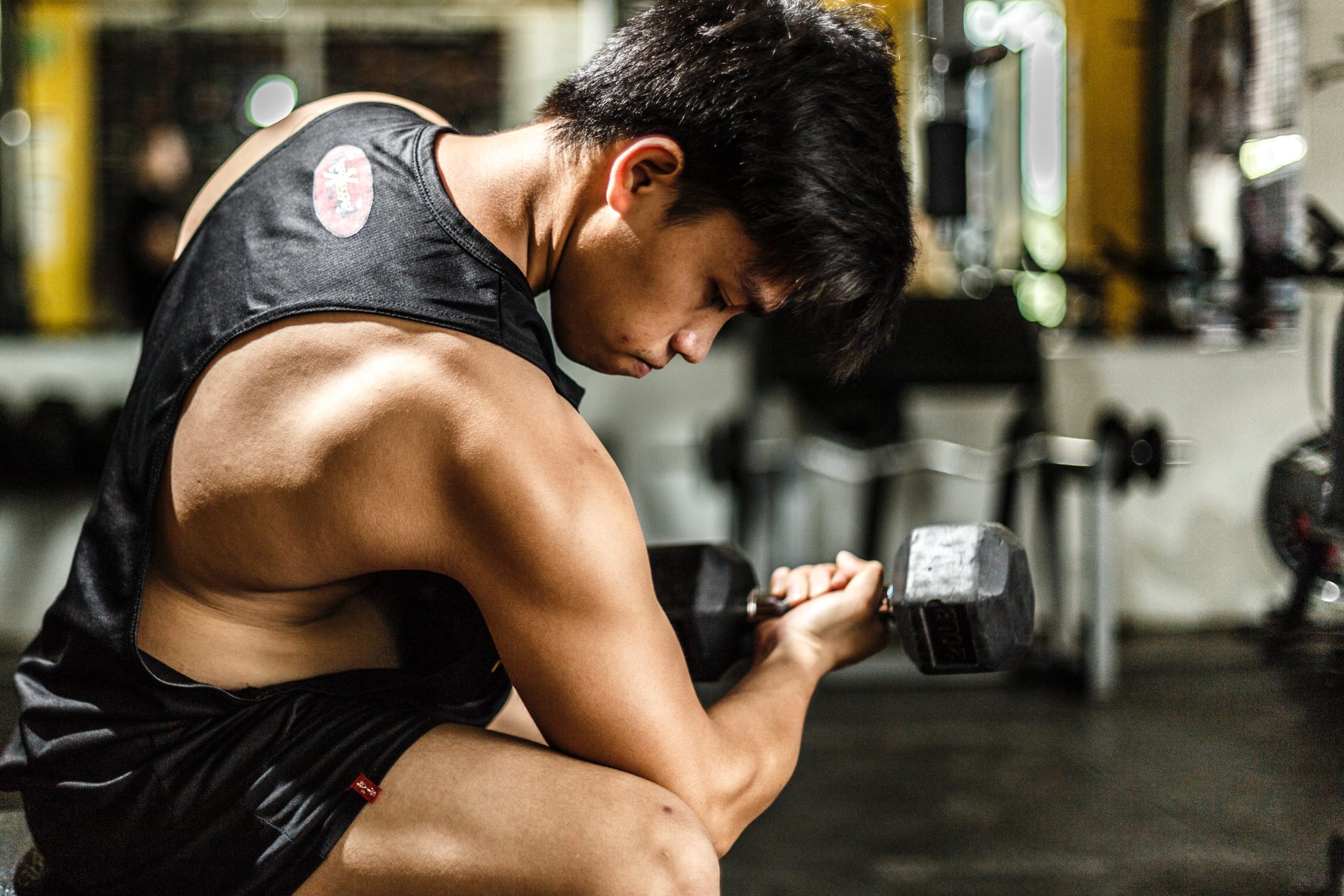 A man flexing his muscles while lifting dumbell