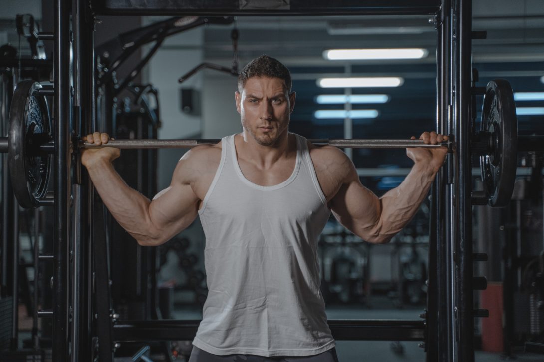 A man lifting a barbell with his muscle showing