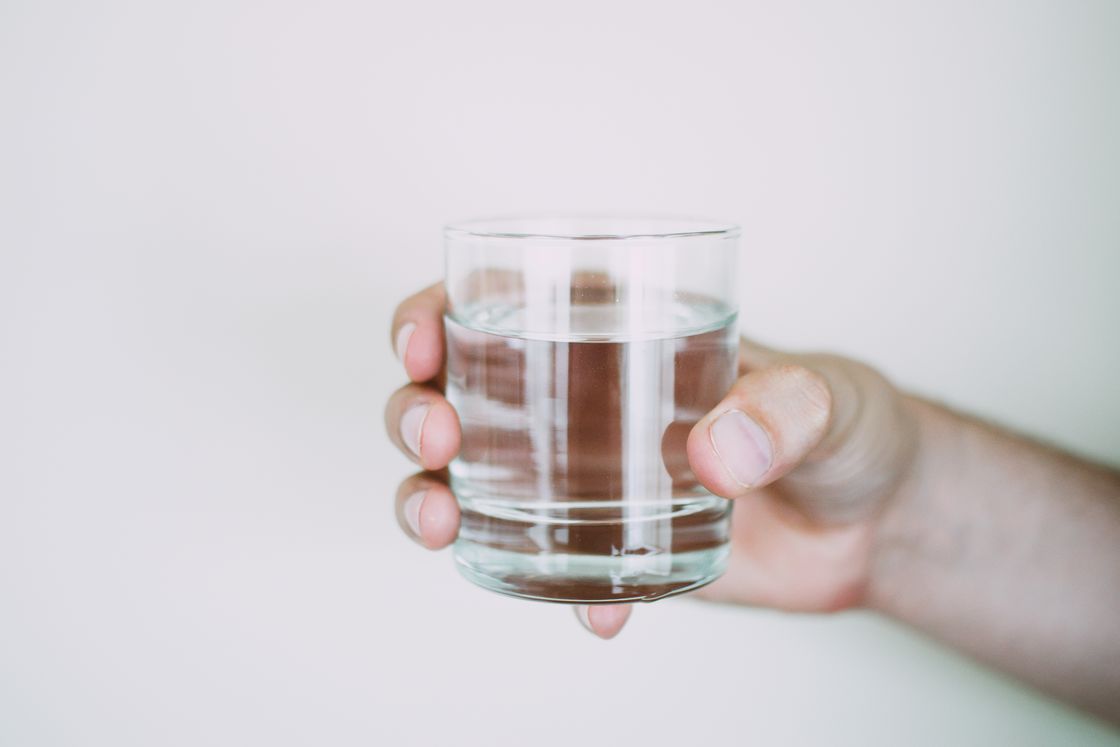 Hand holding a glass of water