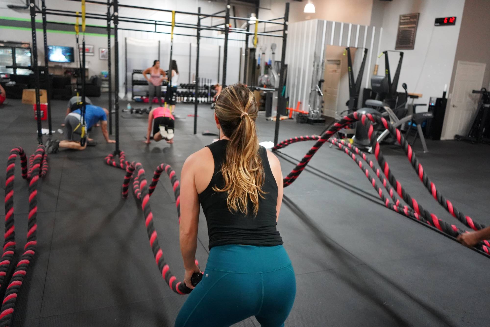 Woman in gym doing battle rope workout