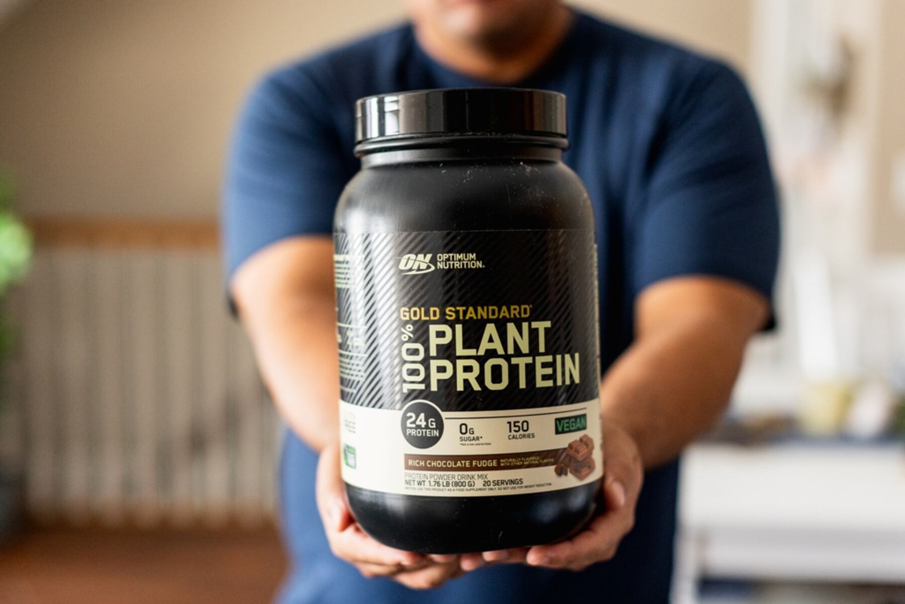 Man holding a bottle of Optimum Nutrition Gold Standard