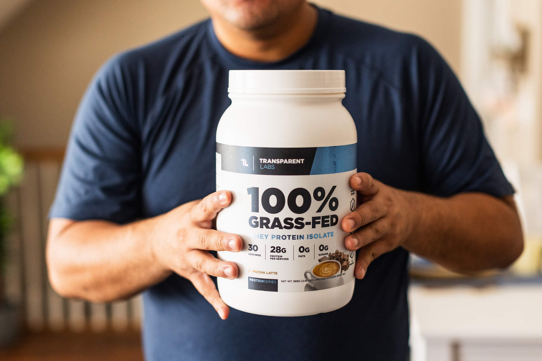 Man holding a bottle of Transparent Lab 100% Grass Fed Protein Isolate