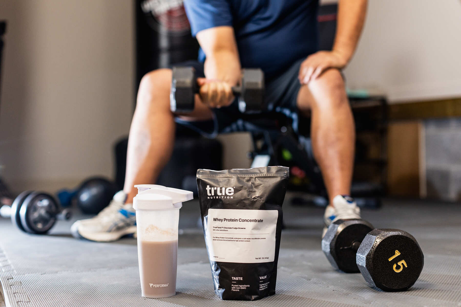 True Whey Protein Powder beside a water bottle filled with protein shake