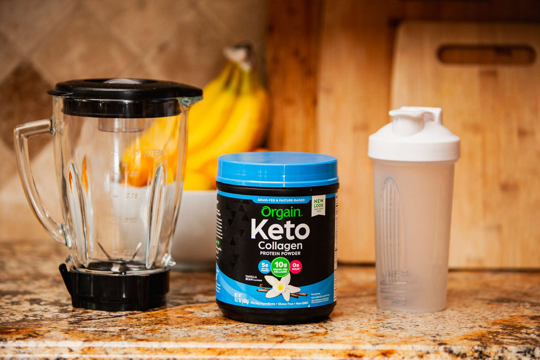 Kitchen counter with a blender, a container of Orgain Keto Collagen Protein Powder in vanilla flavor, and a white shake bottle