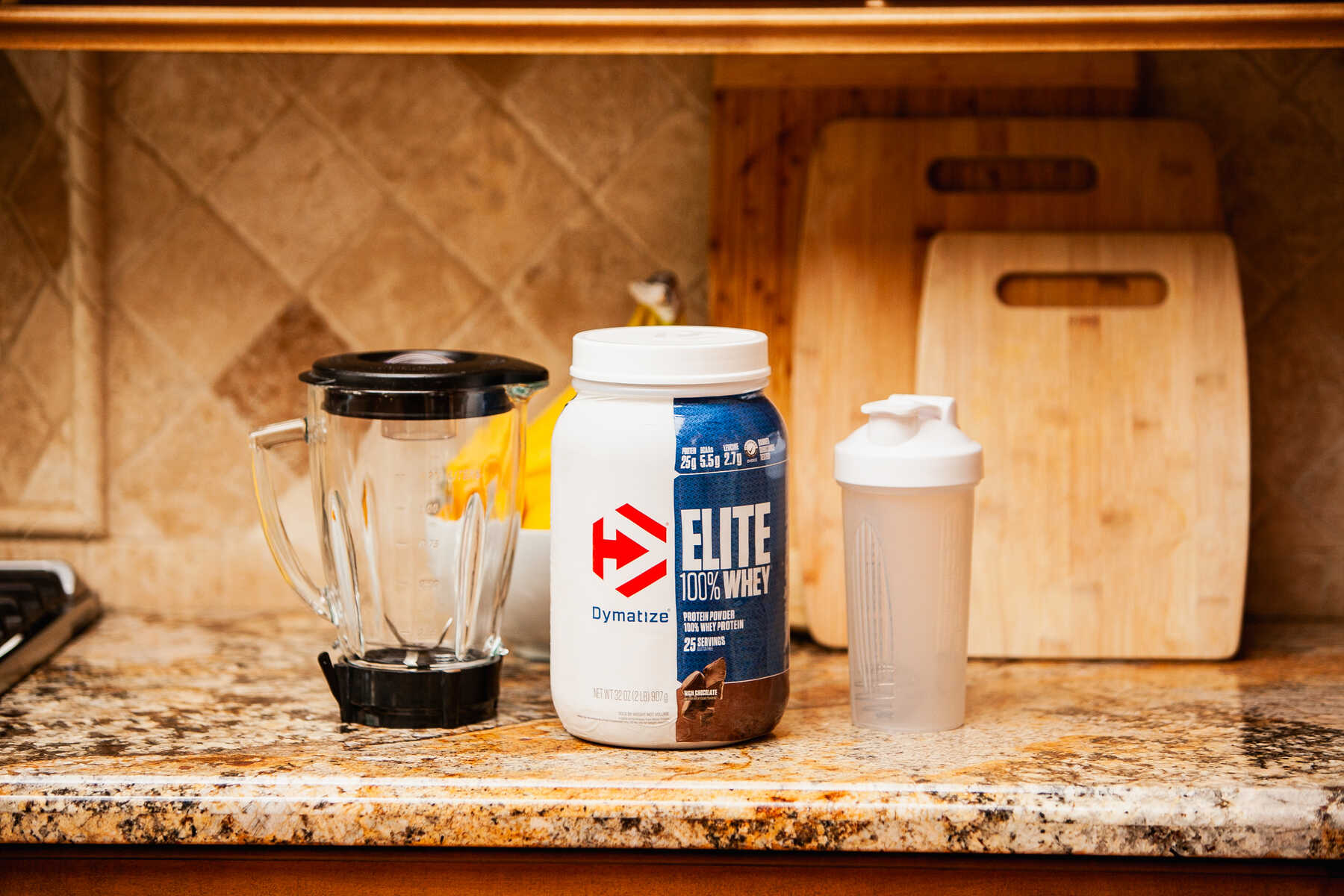 Kitchen counter with whey protein, blender, and shaker