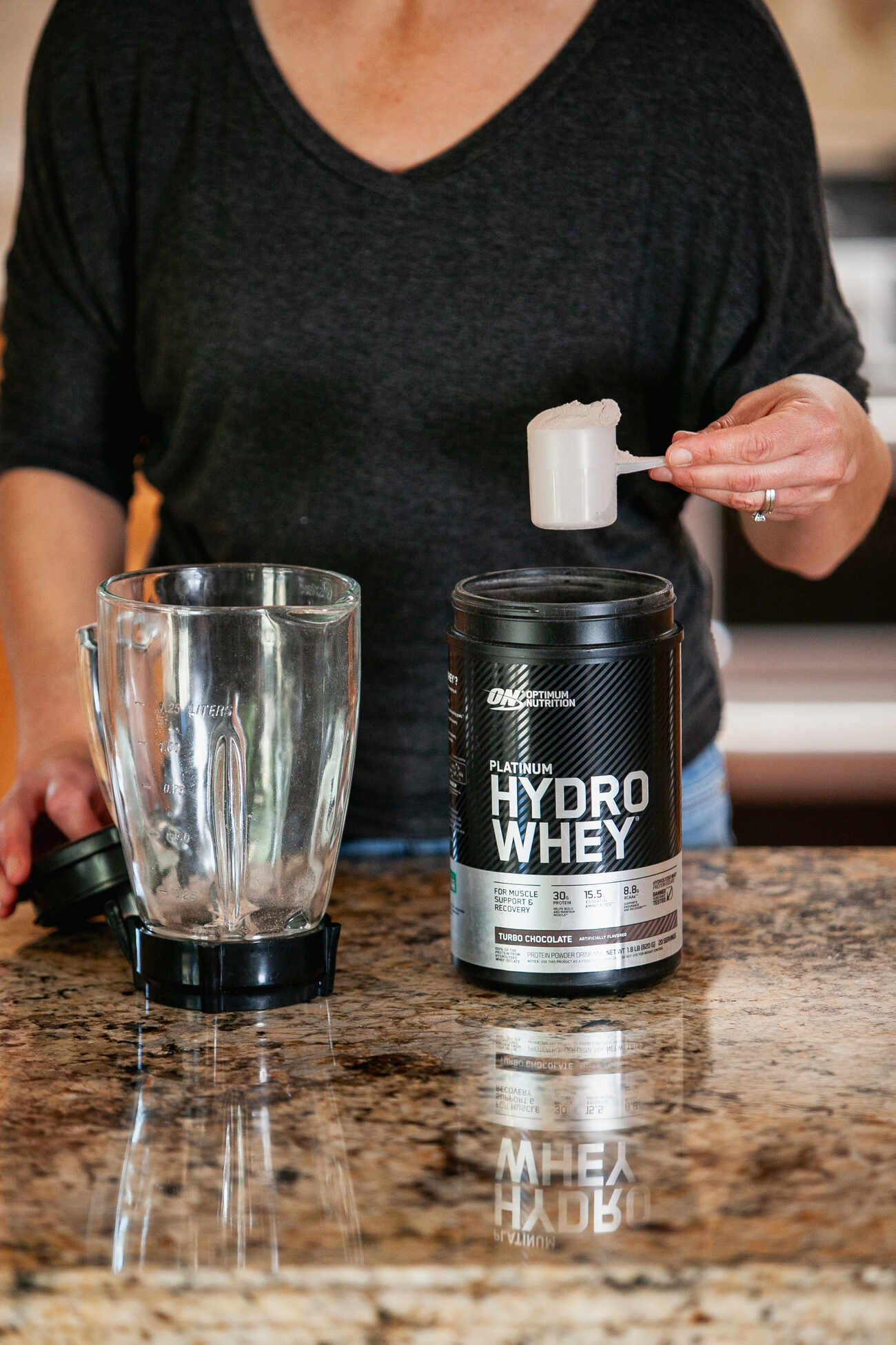 A woman preparing a protein shake with hydrolyzed whey protein