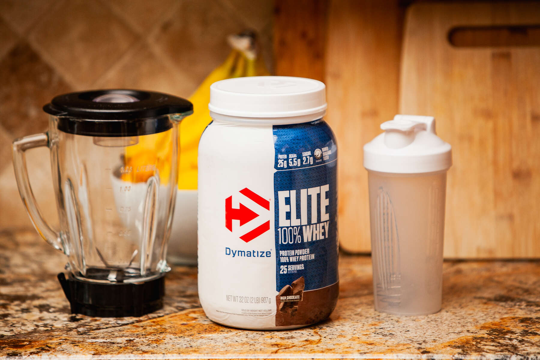 Blender, tumbler and protein supplement on kitchen counter