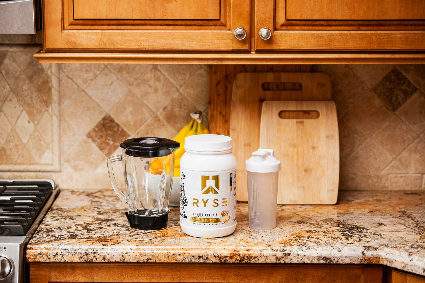 Whey protein, blender, and shaker on kitchen counter