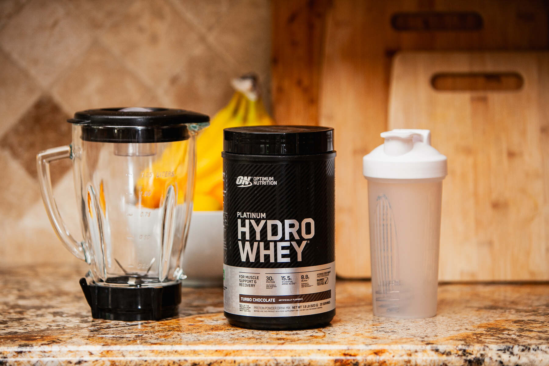 Hydrolyzed whey protein, blender, and shaker on counter