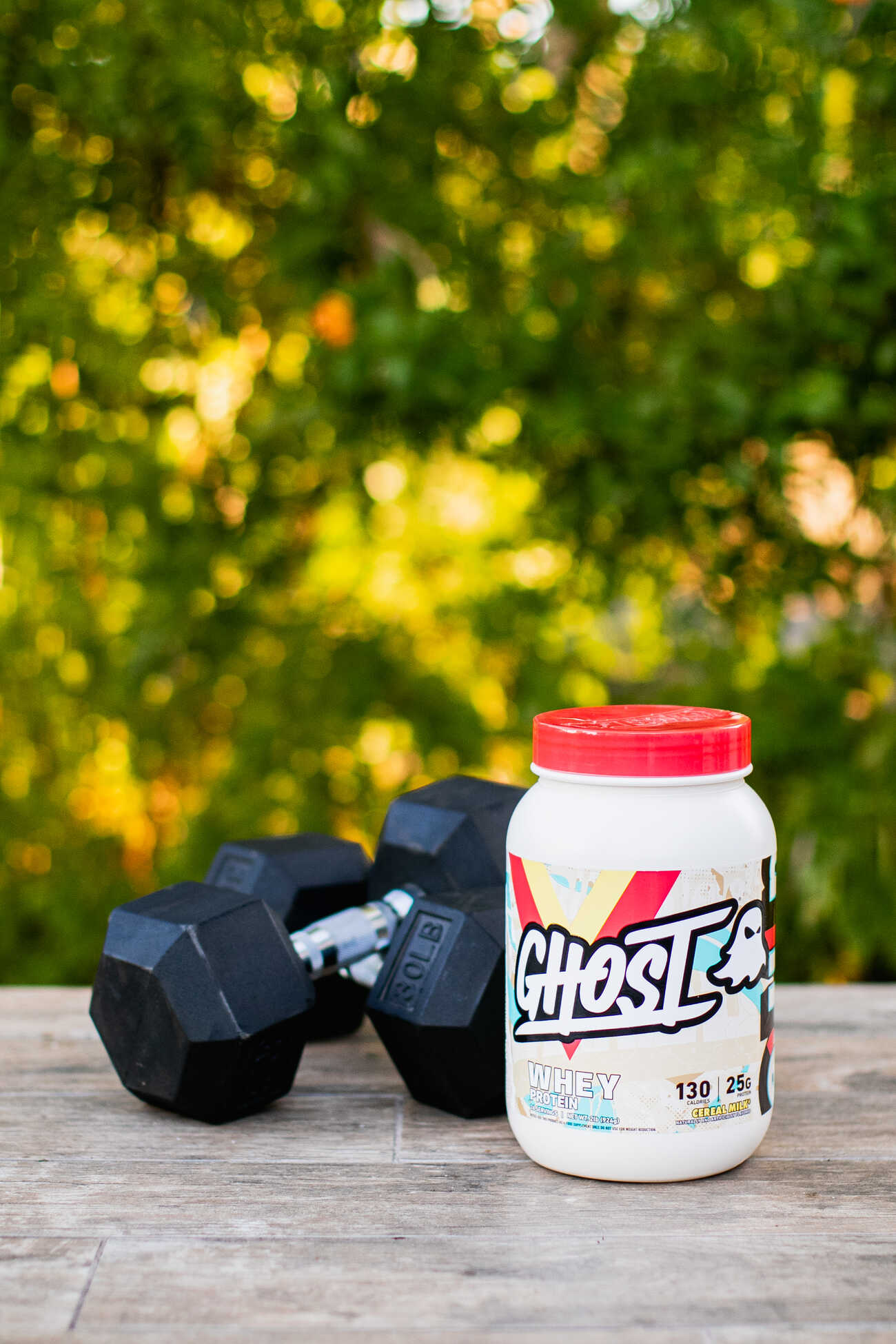 Protein supplement and dumbbells outdoors